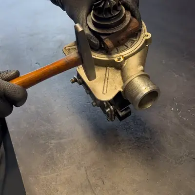 A turbocharger being taken apart with a mallet